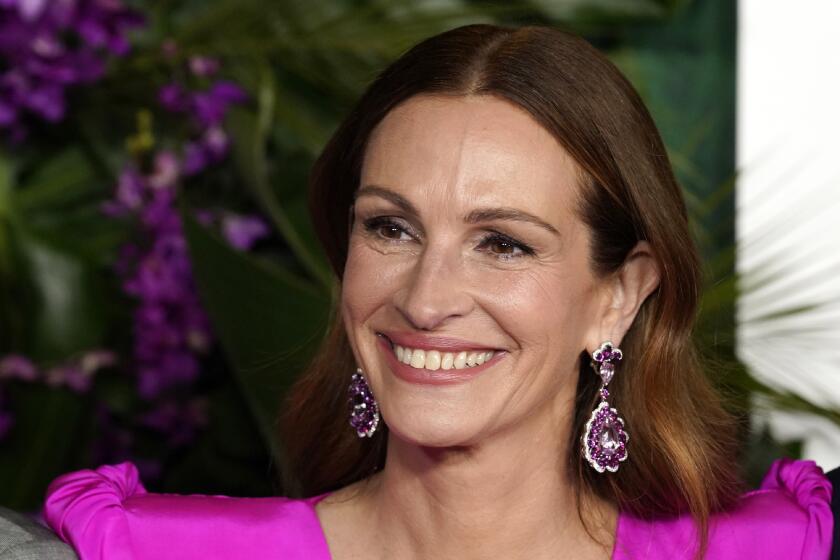 A smiling woman wearing a bright pink gown