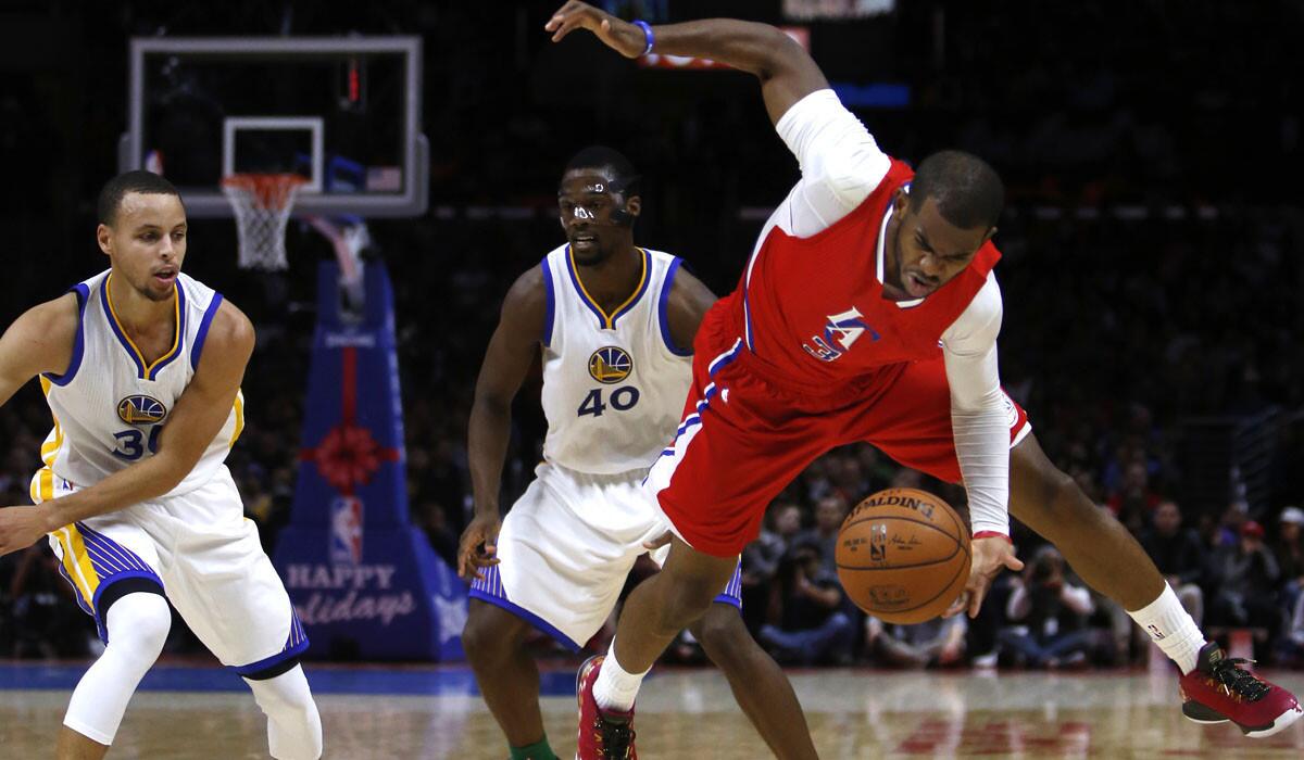 Clippers point guard Chris Paul tries to stop the ball from going out of bounds during the game against the Warriors.