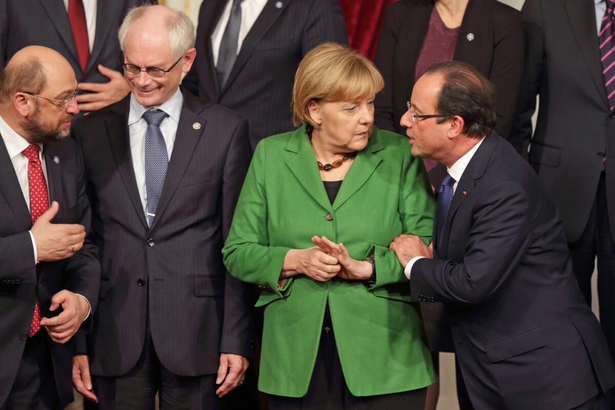 French President Francois Hollande, right, engages German Chancellor Angela Merkel earlier this month at a meeting in Paris where European leaders talked about youth unemployment.