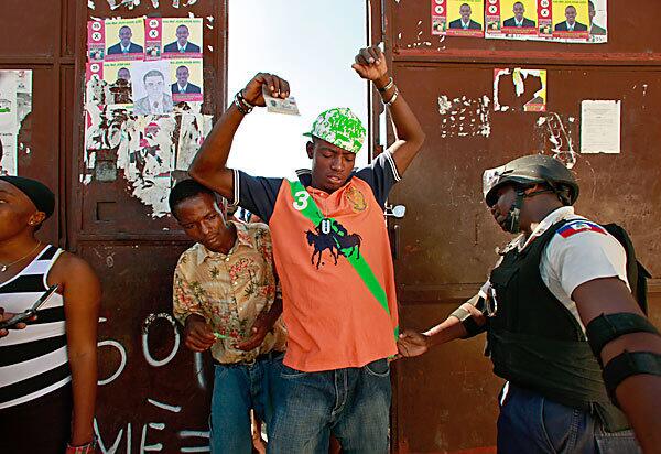 In Port-au-Prince's Cite Soleil neighborhood, voters are frisked by police on the way into the polling station. Haitians are voting on a new president but frustrations are high and many people left polling polling stations without casting their votes.