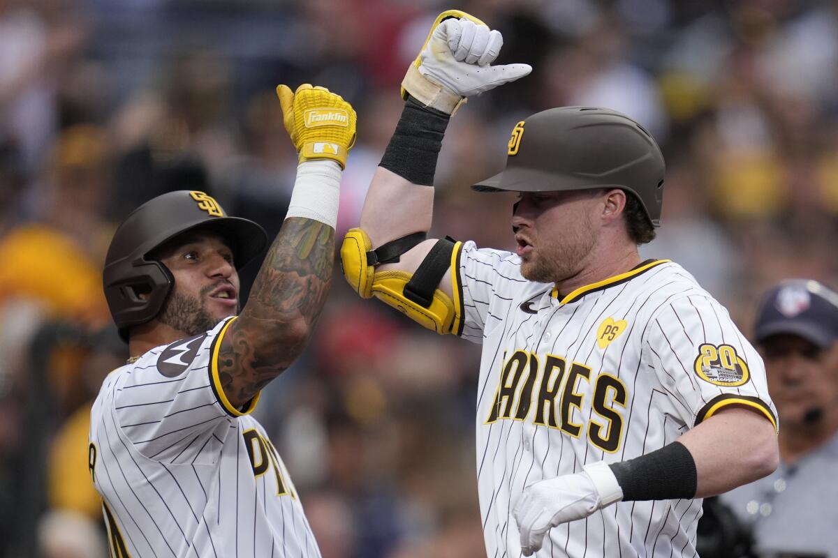 Jake Cronenworth celebra con su compañero venezolano de los Padres de San Diego David Peralta 