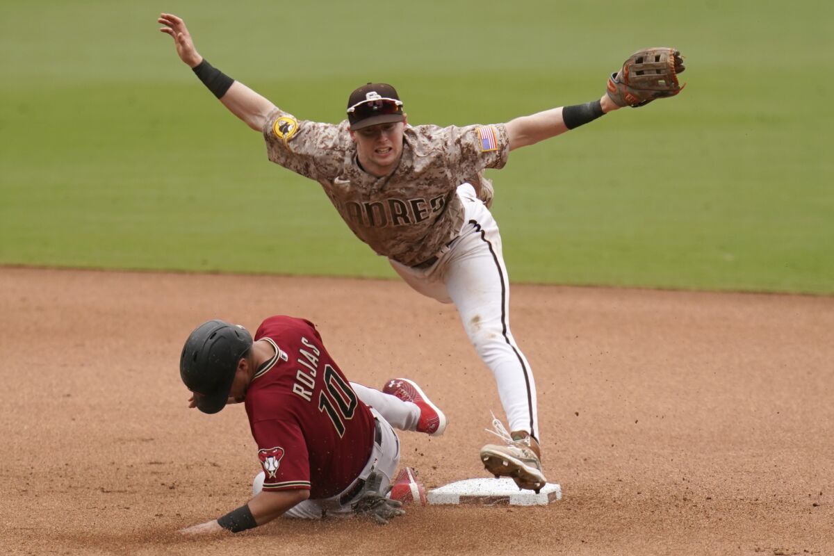 Padres second baseman Jake Cronenworth, top, leaps over Arizona Diamondbacks' Josh Rojas during June 27 game.