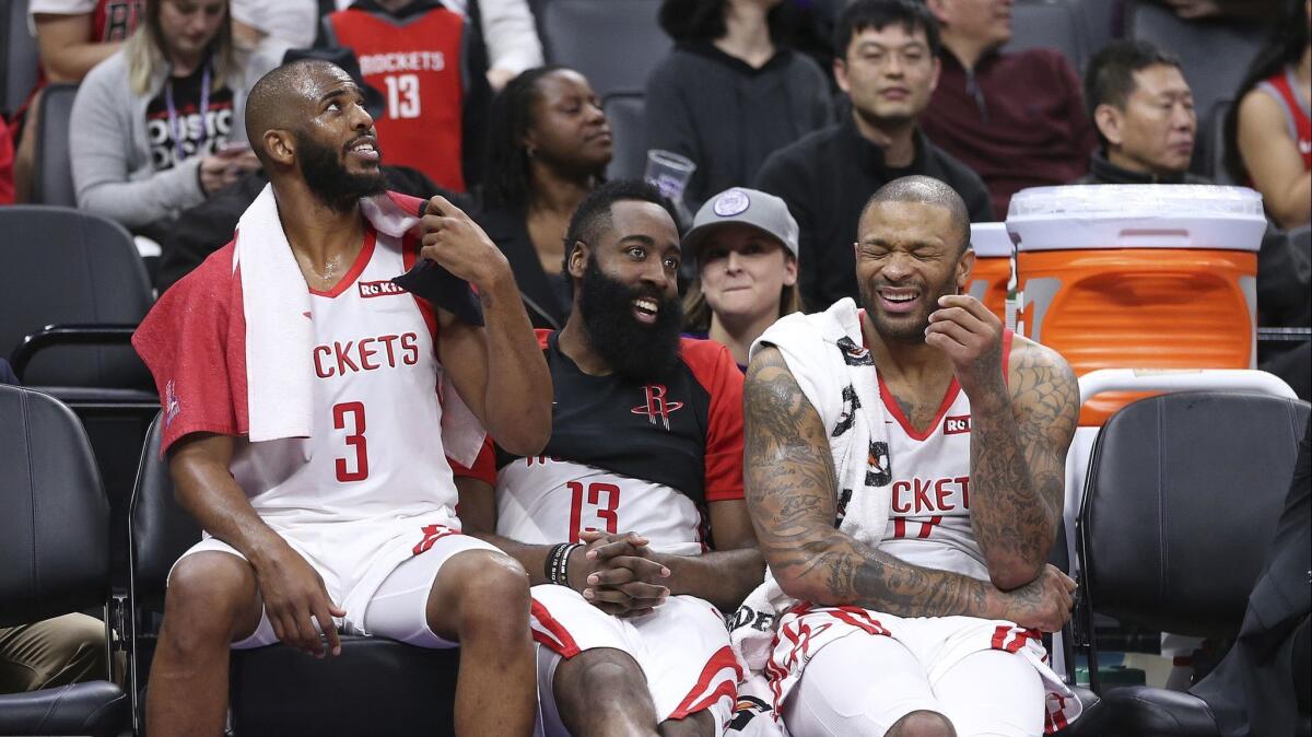 Houston Rockets' Chris Paul, left, James Harden and P.J. Tucker relax on the bench during closing moments of the team's 127-101 win over the Sacramento Kings in an NBA basketball game on Feb. 6 in Sacramento.