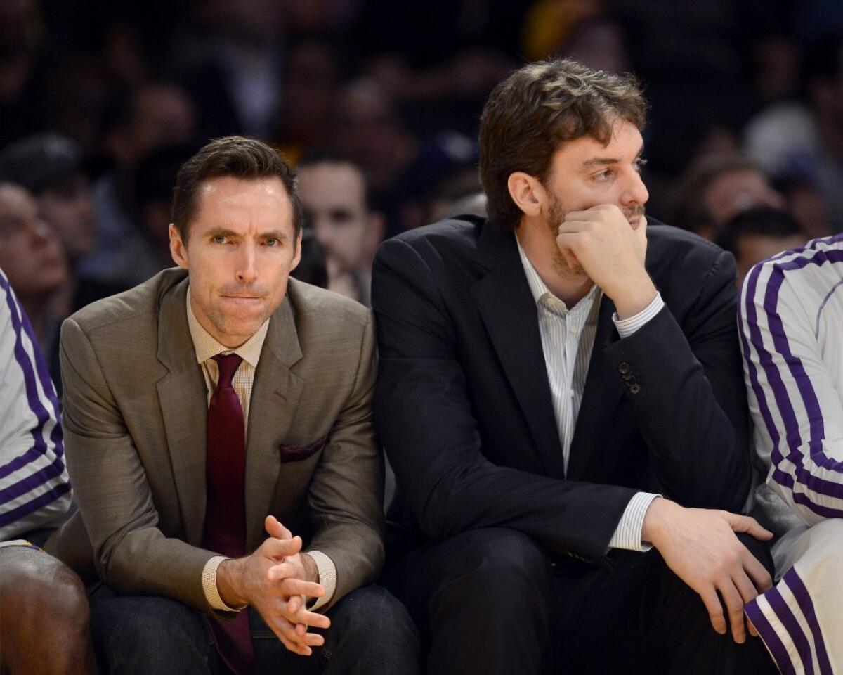 Injured Lakers Steve Nash, left, and Pau Gasol watch from the bench during the loss to Utah on Sunday.