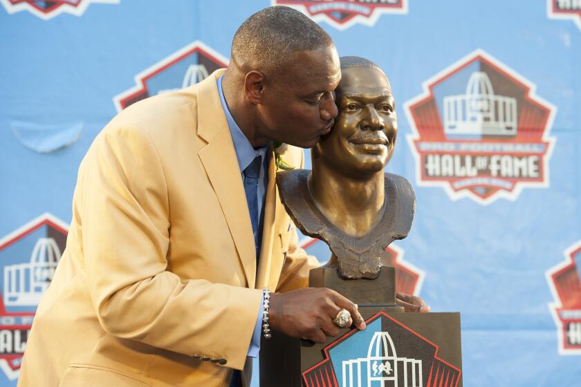 Former Tampa Bay linebacker Derrick Brooks gets friendly with his bust during the Pro Football Hall of Fame induction ceremony Saturday in Canton, Ohio.