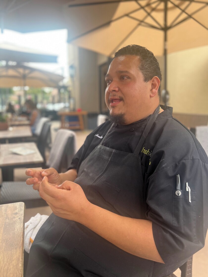 El chef ejecutivo de La Cocina Mesa Moises Hernandez describe los platos del menú.