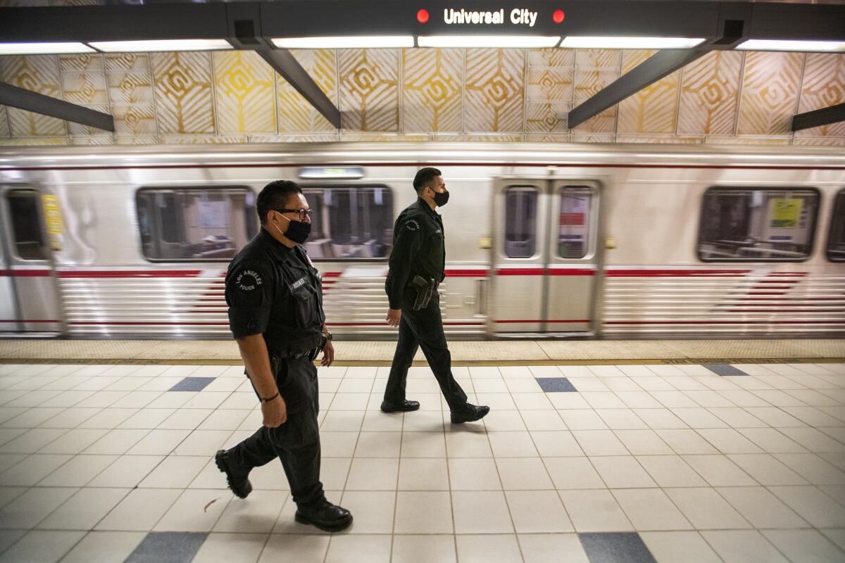LAPD officers E. Rosales, left, and D. Castro patrol Hollywood's Universal City Metro Station in 2020.