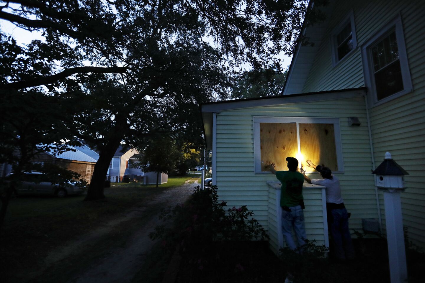 Russell Meadows, left, helps neighbor Rob Muller board up his home ahead of Hurricane Florence in Morehead City, N.C., Tuesday, Sept. 11, 2018. Florence exploded into a potentially catastrophic hurricane Monday as it closed in on North and South Carolina, carrying winds up to 140 mph (220 kph) and water that could wreak havoc over a wide stretch of the eastern United States later this week.