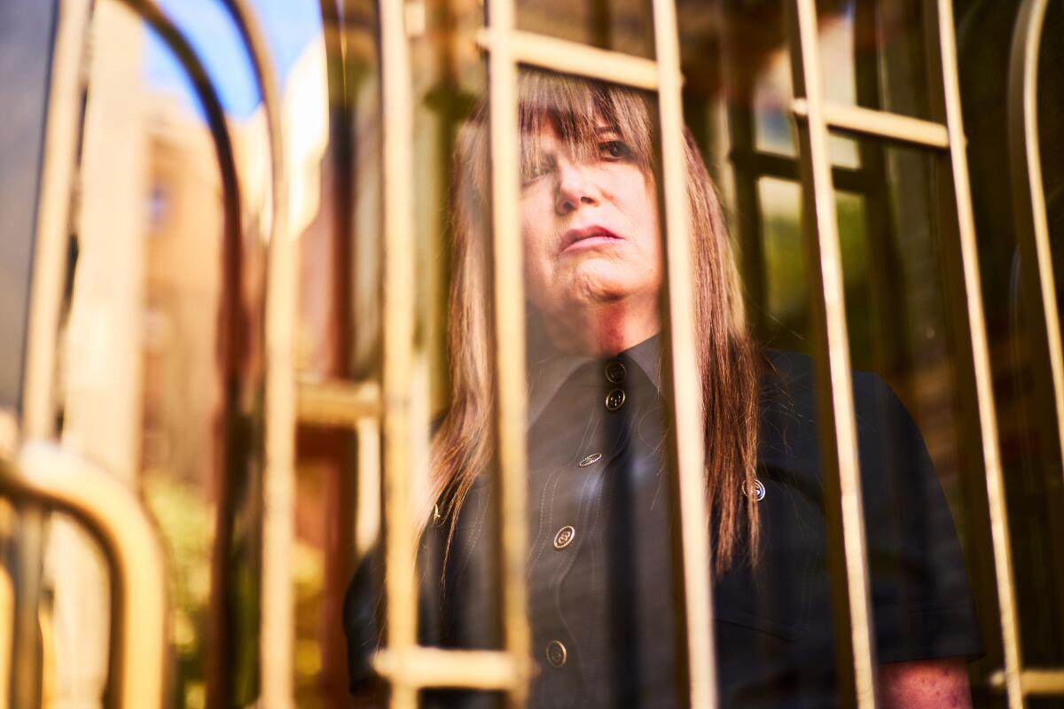 Judy Becker peers out from behind iron railings.