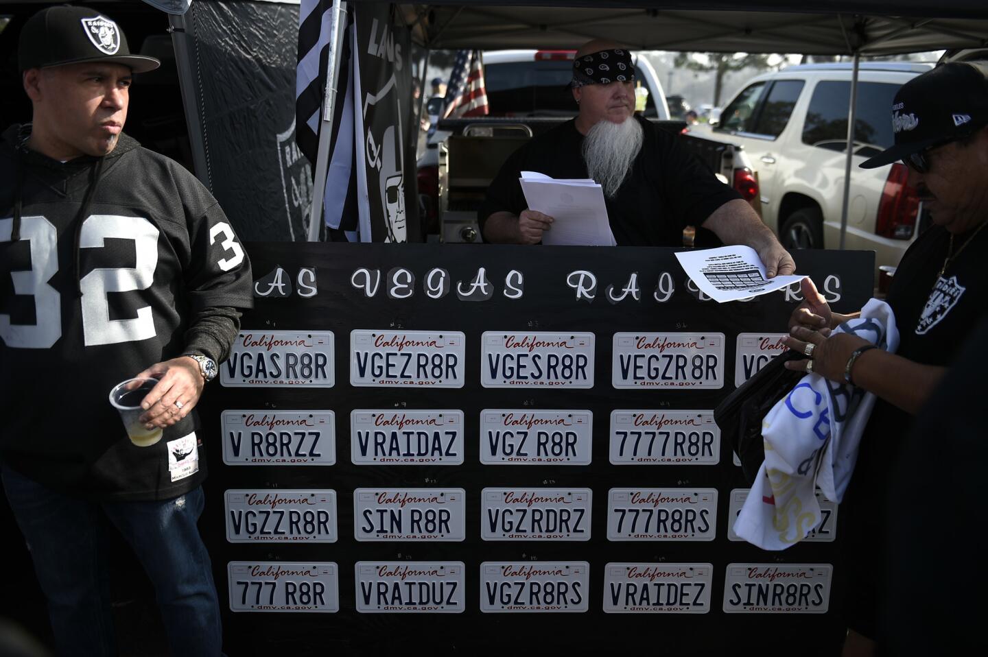 Oakland Raiders fans look on while tailgating before an NFL football game against the Los Angeles Chargers Sunday, Dec. 31, 2017, in Carson, Calif. (AP Photo/Kelvin Kuo)