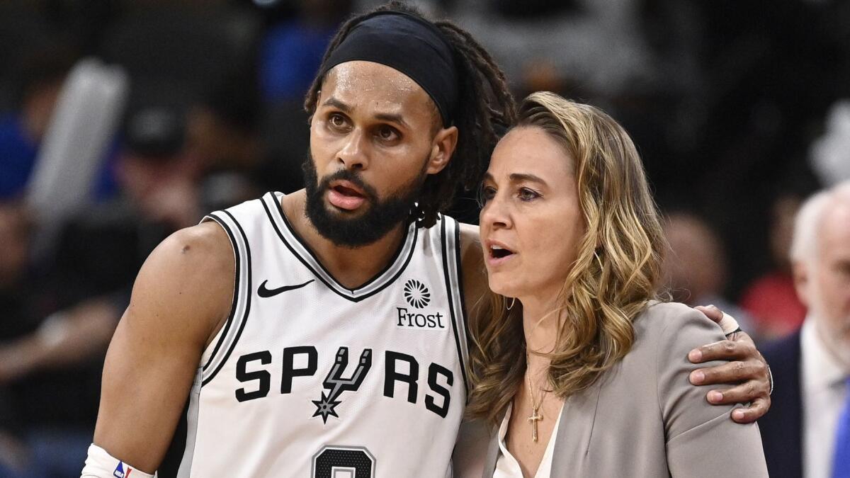 San Antonio guard Patty Mills talks with Spurs assistant coach Becky Hammon during a game against the Atlanta Hawks on April 2.