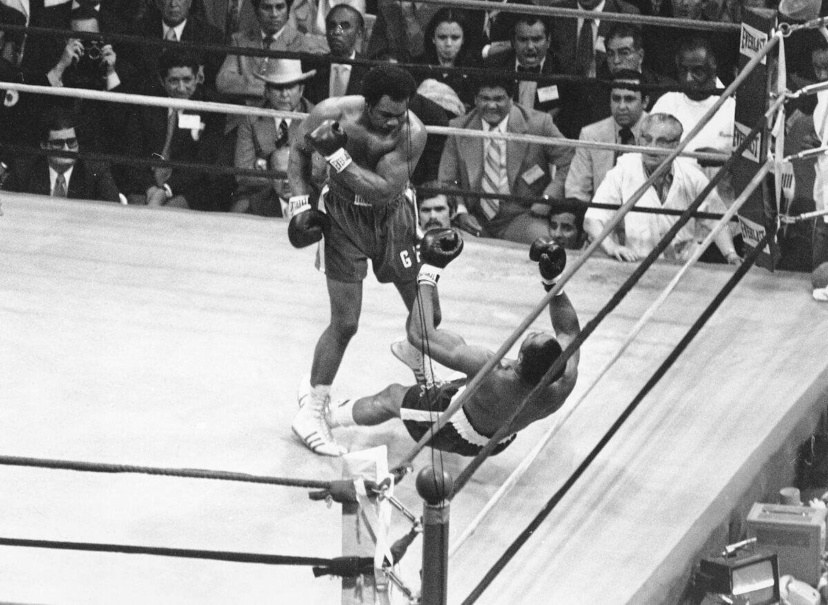 Heavyweight champion George Foreman knocks down Ken Norton during their March 1976 fight in Caracas, Venezuela.
