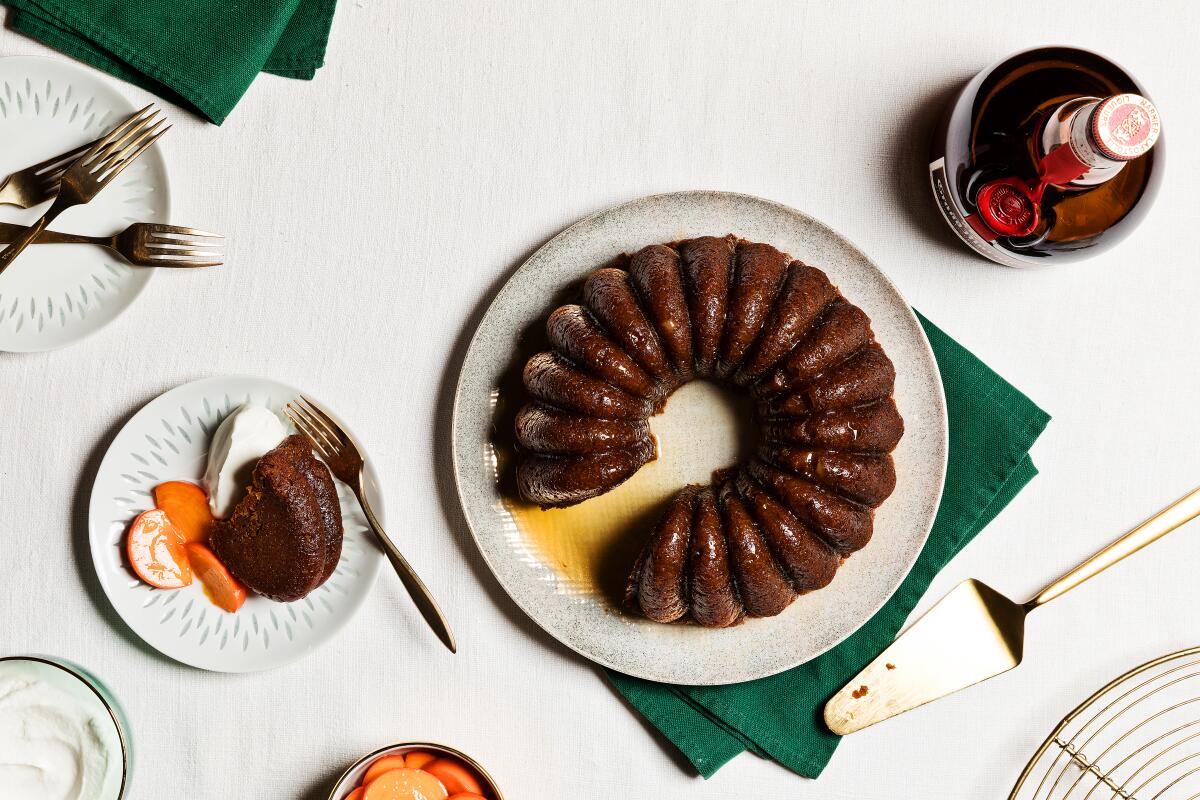 A brown cake from a Bundt pan, with a slice of cake with whipped cream next to it.