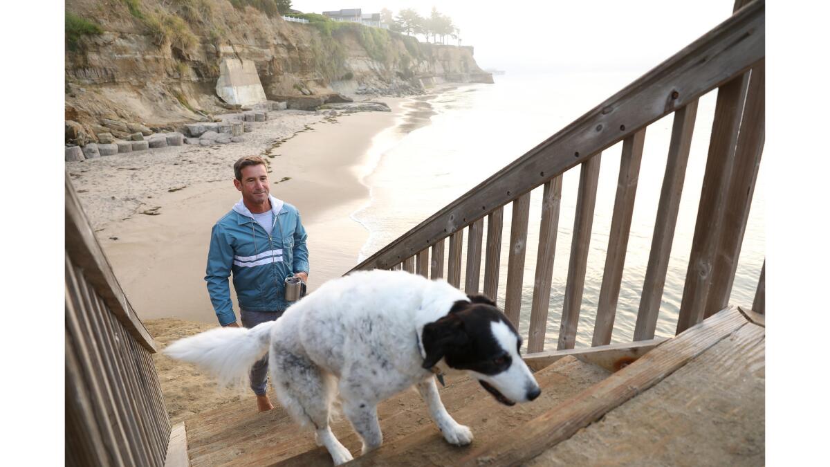 Robert Weaver, known in the surfer community as Wingnut, and his dog Star go for a morning walk in Opal Cliffs.