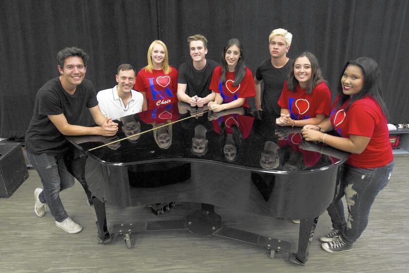Los Alamitos High School choir director David Moellenkamp, playing the piano, along with his students Ryan Ramirez, 17, Kailyn Weber, 17, Chase Graham, 16, Jenna Lea Rosen, 16, Tommy Olaes, 16, Bella Marshall, 17 and Paris Love Robertson, 17, will get to perform with Foreigner onstage in a concert later this month.