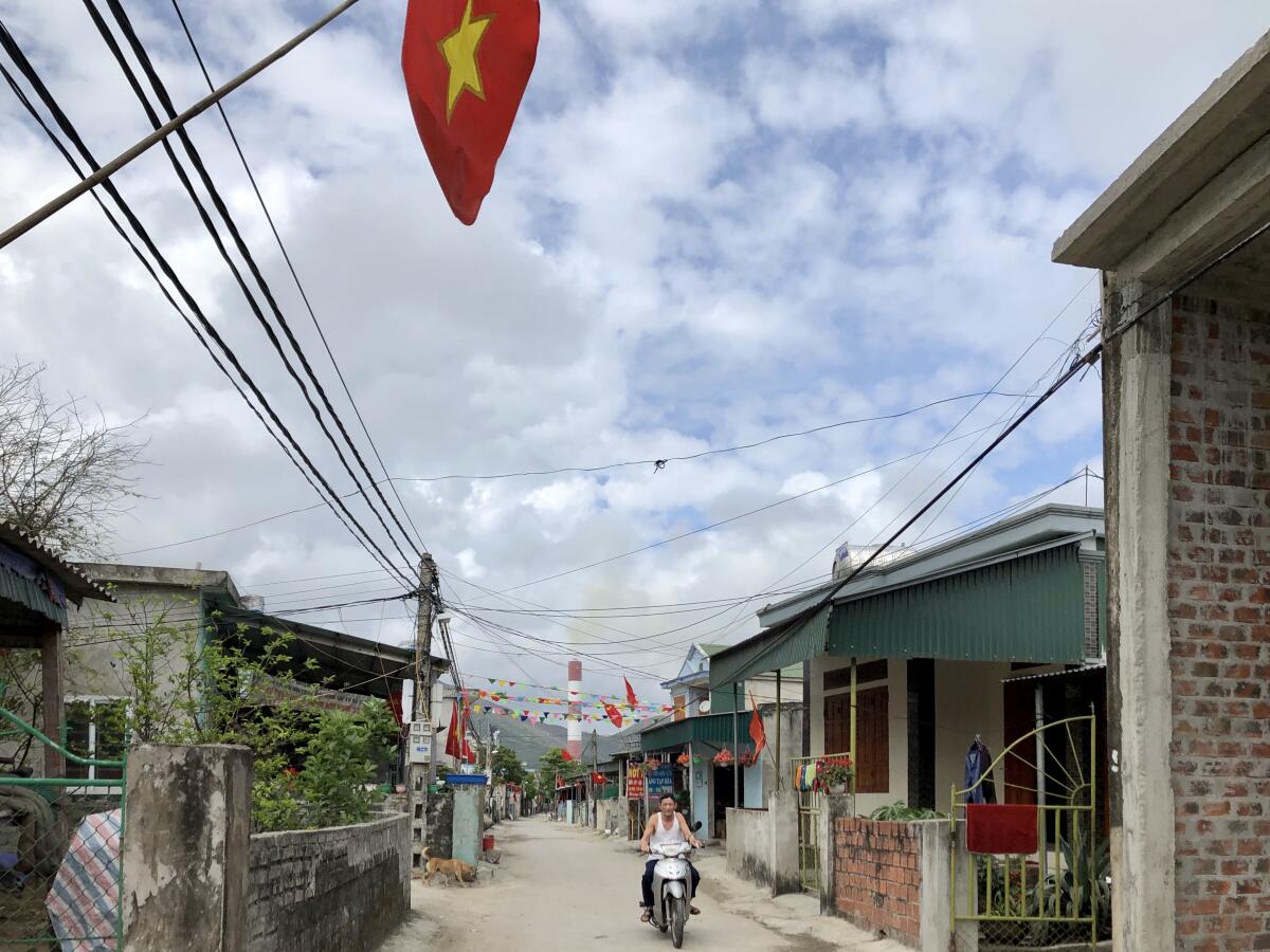 The village of Ky Loi, in northeastern Vietnam, with the smokestack of the Vung Ang I power plant seen in the distance.