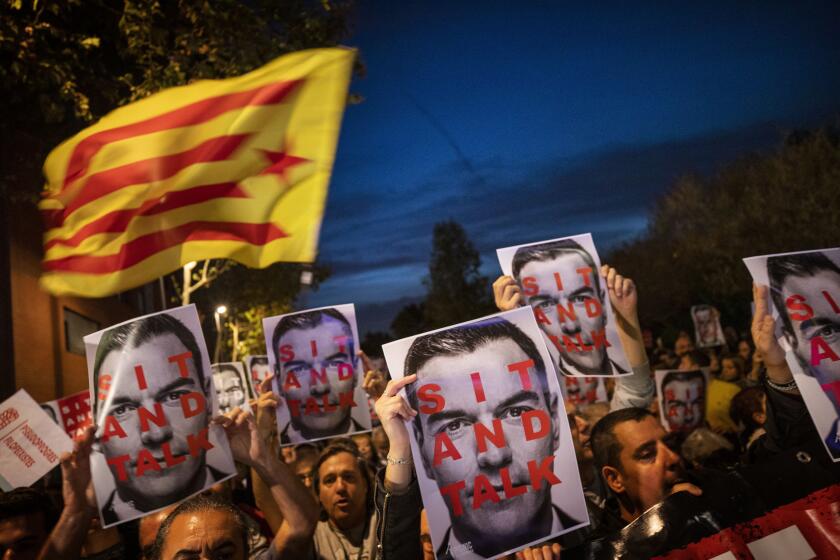 FILE - Catalonia pro-Independence demonstrators hold photos of Prime Minister and Socialist leader Pedro Sánchez, as they wait for his arrival outside a campaigning meeting in Viladecans, near Barcelona, Spain, on Oct. 30, 2019. Spain's coalition government has presented a proposal in Parliament to reform the centuries-old crime of sedition for one of public disorder, which would carry lower sentences. Sedition was one of the main charges against pro-independence Catalan activists and politicians that were jailed for their roles in a 2017 secession bid. The proposal comes as the government continues talks with the Catalan regional government to reduce tensions stemming from that period.(AP Photo/Emilio Morenatti)