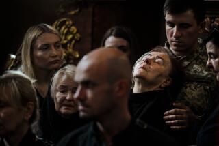 LVIV, UKRAINE -- JUNE 20, 2023: Uliana, 78, leans her head back as Captain Mishchenko supports her from behind as she mourns for Yuriy Sikyrynsky, her son who was killed in action near Rozdolivka, during a military funeral for three soldiers killed in action, at the Saints Peter and Paul Garrison Church in Lviv, Ukraine, Tuesday, June 20, 2023. UkraineOs summer counteroffensive against invading Russian troops is exacting a heavy but undisclosed toll on the armies of both sides. In towns and cities across Ukraine, as bodies are returned home for burial, the burden of grief grows. (MARCUS YAM / LOS ANGELES TIMES)