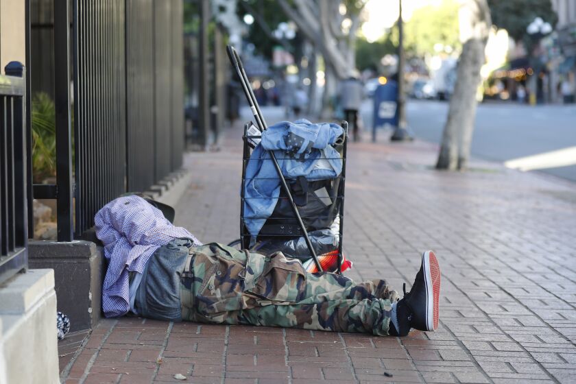 The Supreme Court refused to hear a major case on homelessness, letting stand a ruling that protects homeless people's right to sleep on the sidewalk or in a public park if no other shelter is available. Here, a homeless man sleeps on the sidewalk in downtown San Diego on Dec. 16, 2019.