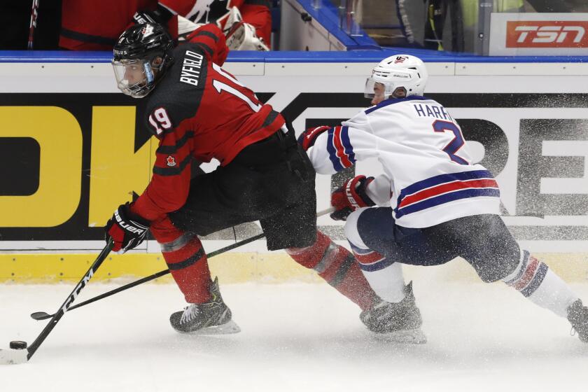 Jordan Harris of the US, right, challenges Canada's Quinton Byfield, left, during the U20 Ice Hockey Worlds match between Canada and the United States in Ostrava, Czech Republic, Thursday, Dec. 26, 2019. (AP Photo/Petr David Josek)