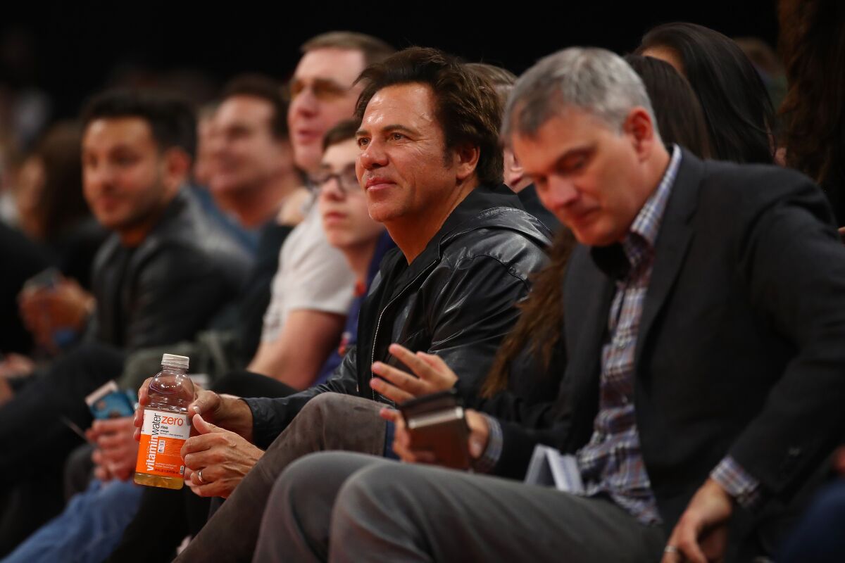 Detroit Pistons owner Tom Gores, center, watches a game against the Toronto Raptors in Detroit in 2018.