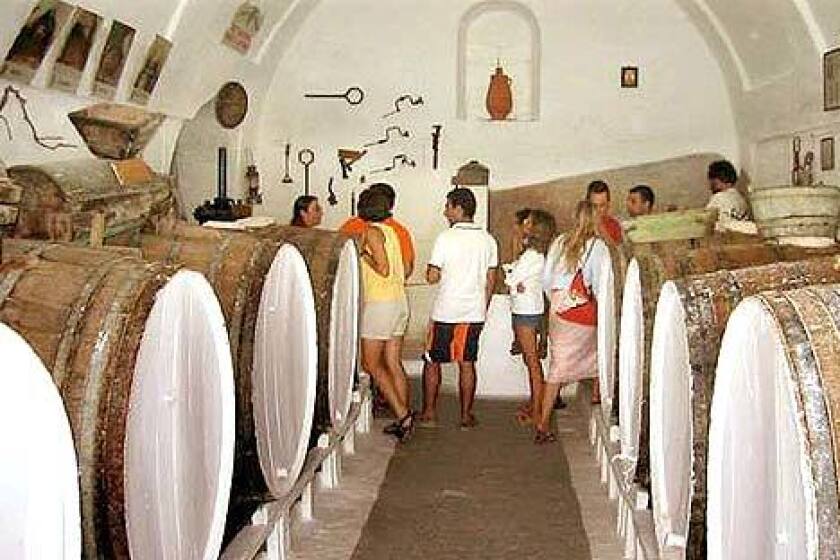 Visitors tour the wine cellar at Canava Roussos on the island of Santorini. The winery also has a good restaurant.