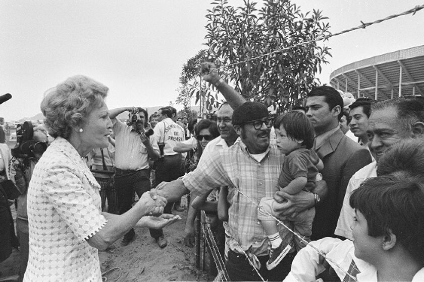Former First Lady Pat Nixon shakes hands across the barbed wire border fence after announcing the creation of Friendship Park, intended to be a binational park celebrating the relationship of the United States and Mexico.