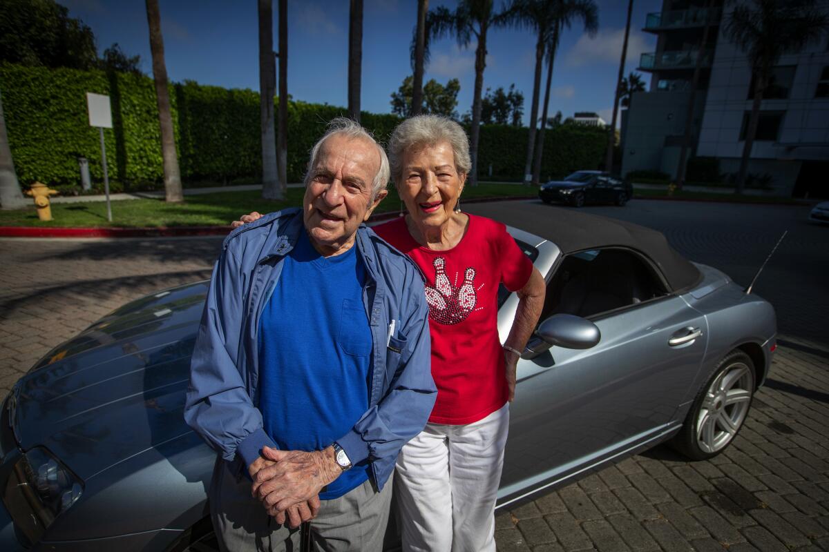 Lillian Solomon with her 99-year-old boyfriend, Eddie Huyffer, in front of her Crossfire convertible. They first met 25 years ago while bowling.
