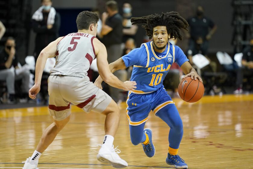 UCLA guard Tyger Campbell (10) dribbles around Stanford guard Michael O'Connell.