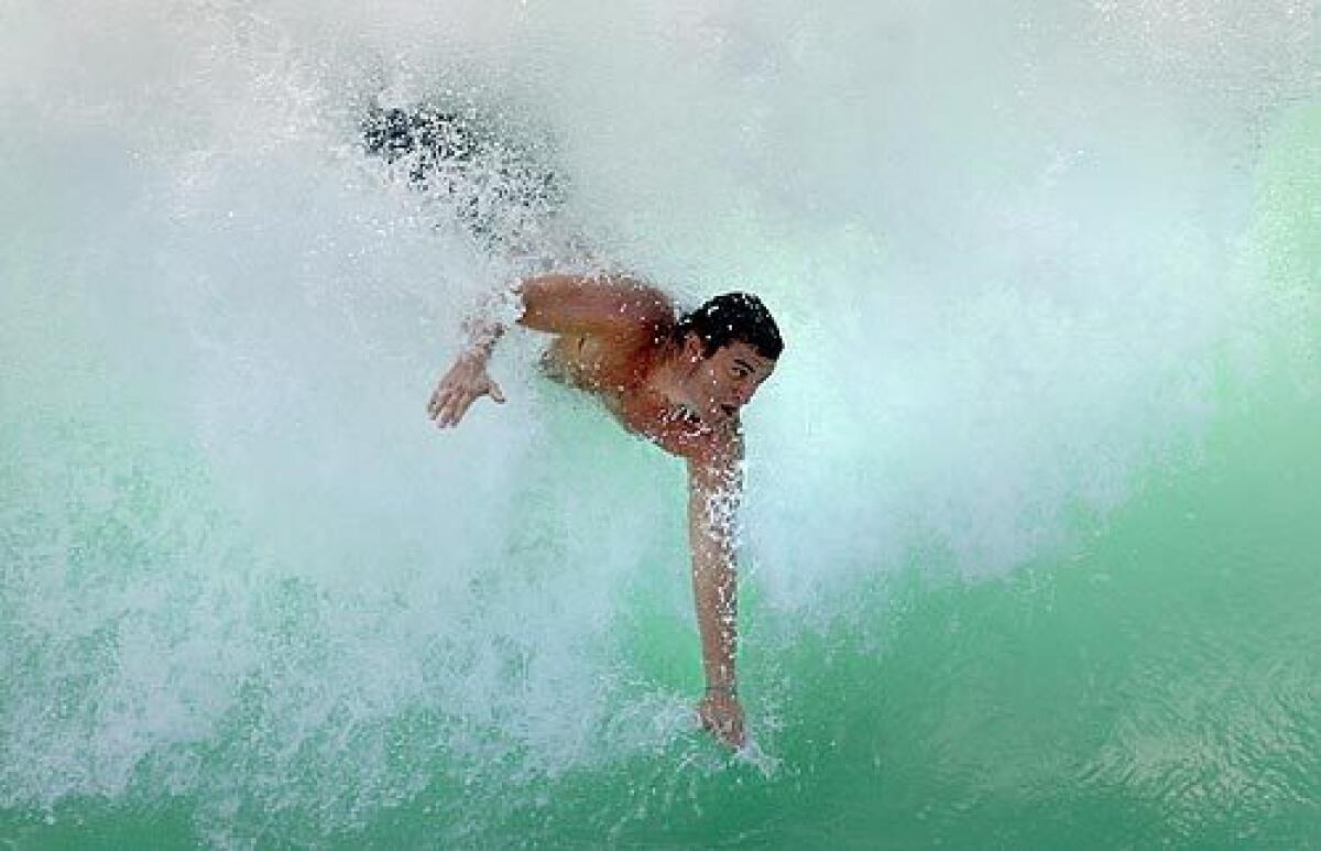 A body surfer takes off on one of the huge waves at the Wedge in Newport Beach, off the rocky jetty at the tip of Balboa Peninsula.