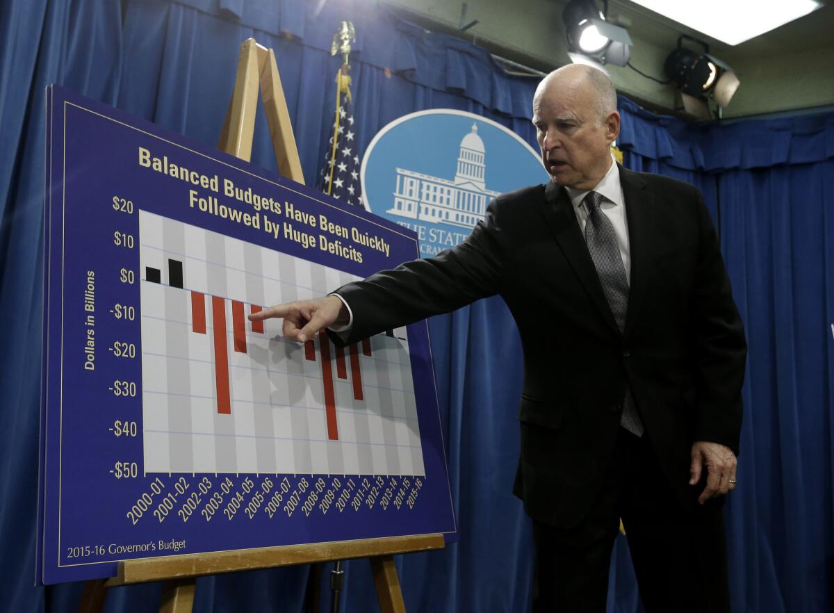 During a Jan. 9 briefing in Sacramento, Gov. Jerry Brown points to a chart showing the ups and downs in California's finances in the last 15 years.