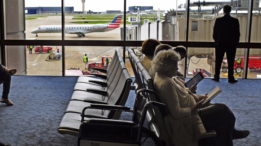 Passengers wait for their flights as an American Eagle Airlines aircraft taxis to the runway at Dallas/Fort Worth International Airport.