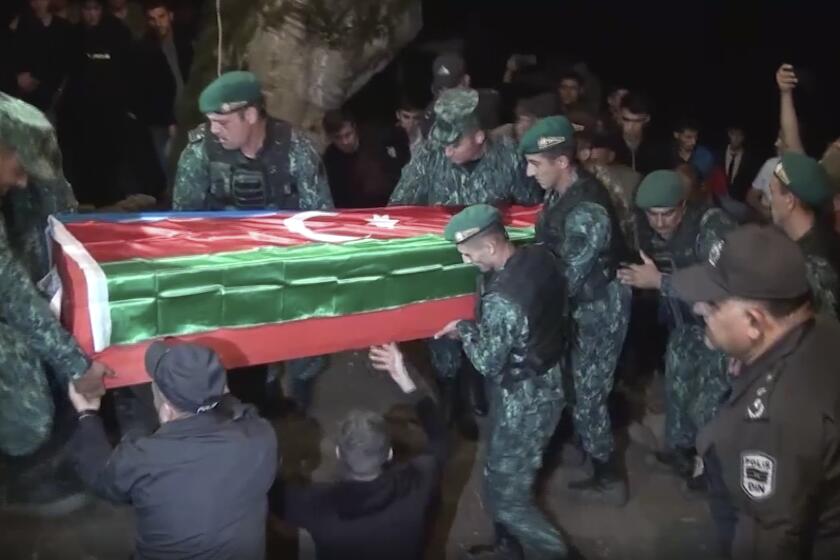 In this image taken from video, servicemen carry a coffin of Azeri serviceman Shamistan Sadykhov killed at Azerbaijani-Armenian border, during his funeral in Lerik, Azerbaijan, Tuesday, Sept. 13, 2022. Armenia and Azerbaijan accused each other of new rounds of shelling on Wednesday morning as hostilities reignited between the two longtime adversaries. (AP Photo)