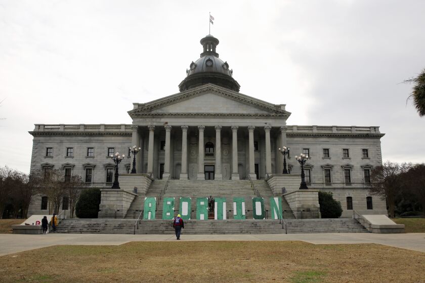 A group who opposes a bill that would ban almost all abortions in South Carolina put up a sign outside the Statehouse on Tuesday, Feb. 2, 2021, in Columbia, S.C. The bill has passed the Senate and been sent to the House. (AP Photo/Jeffrey Collins)