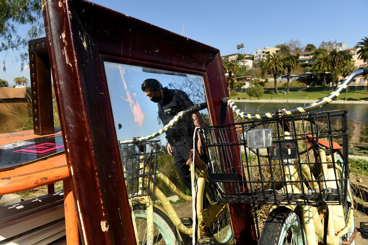 A police officer is reflected in a mirror next to a bicycle in Echo Park.