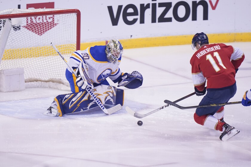 Florida Panthers left wing Jonathan Huberdeau (11) attempts a shot at Buffalo Sabres goaltender Aaron Dell (80) during the first period of an NHL hockey game, Thursday, Dec. 2, 2021, in Sunrise, Fla. (AP Photo/Wilfredo Lee)