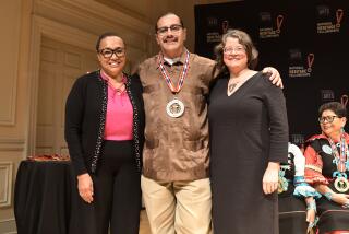 2024 NEA National Heritage Fellow Fabian Debora receives a medal during a ceremony at the Library of Congress in Washington, DC on September 18, 2024. He is joined on stage by NEA Chair Maria Rosario Jackson (left) and NEA Folk & Traditional Arts Lead Erin Waylor (right). For more information, visit arts.gov/heritage. Photo by Tom Pich