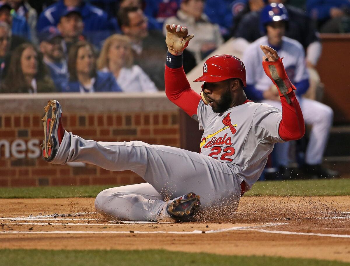 Cardinals outfielder Jason Heyward slides in with the first run of the Major League Baseball season. The Cardinals beat the Cubs, 3-0.
