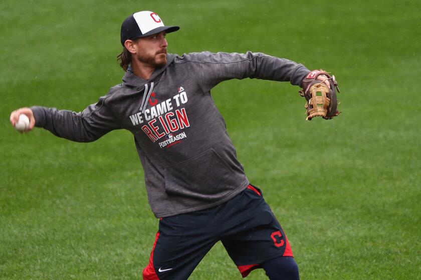 Indians starter Josh Tomlin loosens up on the soggy Fenway Park field after Game 3 of the ALDS was postponed until Monday.