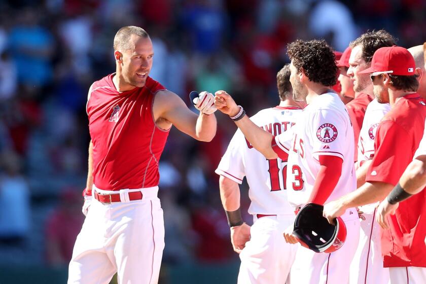 David Murphy, left, is congratulated by Angels teammate David DeJesus (3) after deliver a walk-off hit against the Orioles in the 11th inning Sunday afternoon in Anaheim.