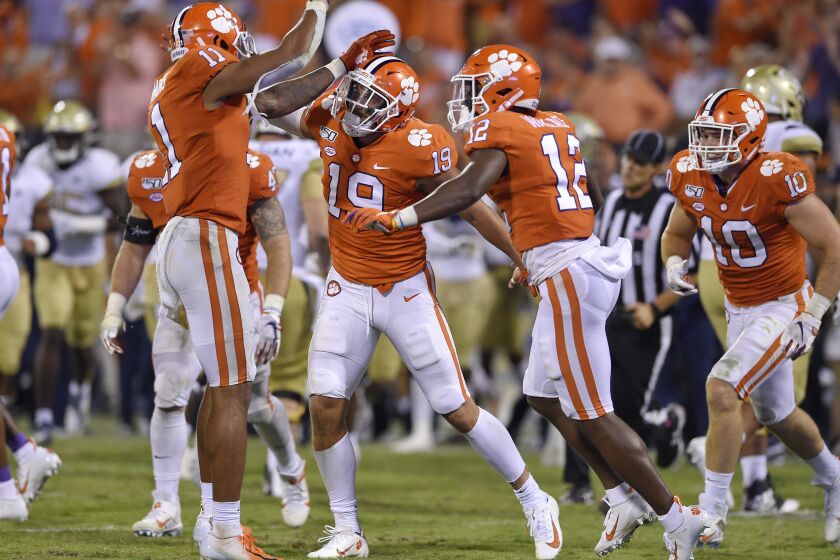 Clemson's Tanner Muse, center, Isaiah Simmons, left, and K'Von Wallace celebrate Muse's interception during the second half of an NCAA college football game against Georgia Tech Thursday, Aug. 29, 2019, in Clemson, S.C. Clemson won 52-14. (AP Photo/Richard Shiro)