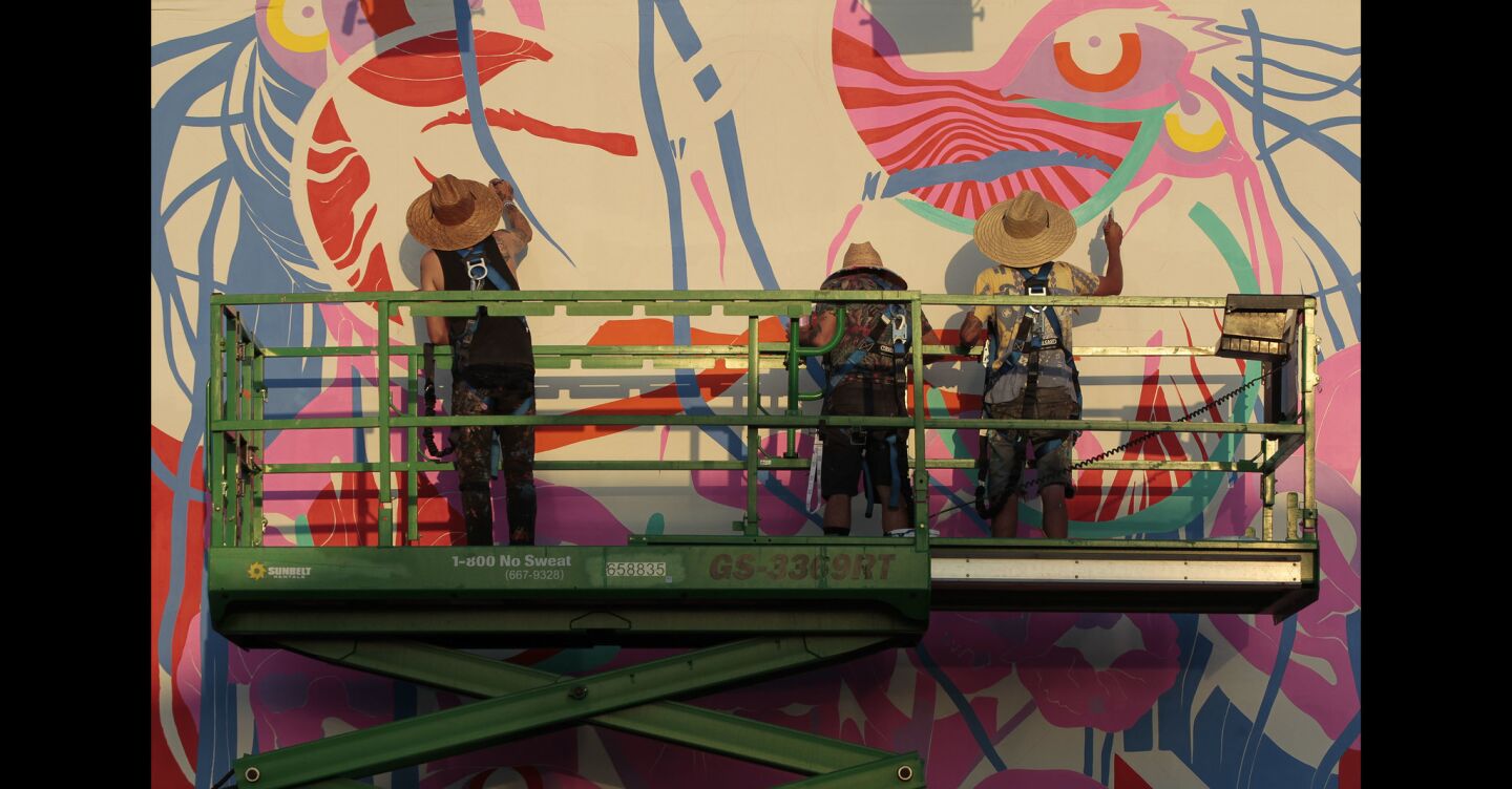 Artists work on a mural during KAABOO.