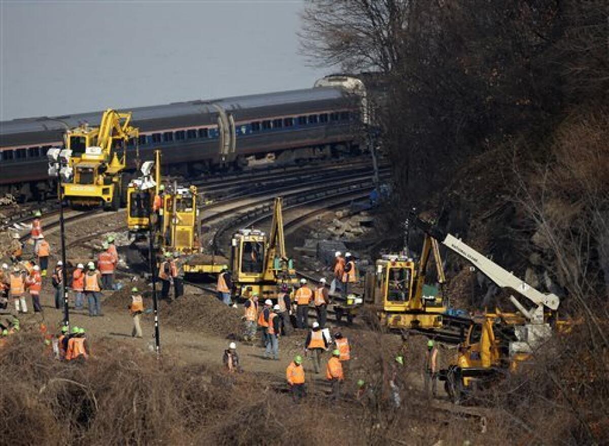 A train passes the site of a New York train derailment, where recovery efforts are underway.