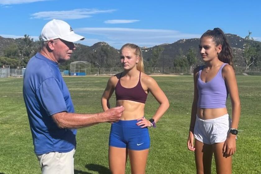 Terry Dockery coaching Rancho Bernardo's Madison Lorenz (middle) and Riley Biddle (right).