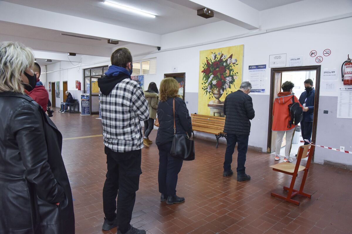 Kosovars wait to cast their ballot at a polling station in Pristina, Kosovo, Sunday, Oct. 17, 2021. Kosovo is holding municipal elections Sunday in which the eight-month-old leftwing governing party aims at capturing the capital Pristina's city hall. (AP Photo/Visar Kryeziu)