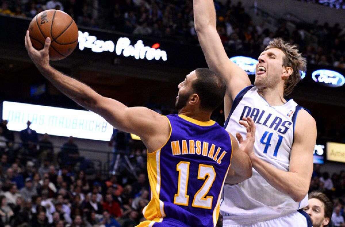 Lakers point guard Kendall Marshall puts up a shot against Dallas Mavericks forward Dirk Nowitzki during the second half of the Lakers' 110-97 road loss Tuesday.
