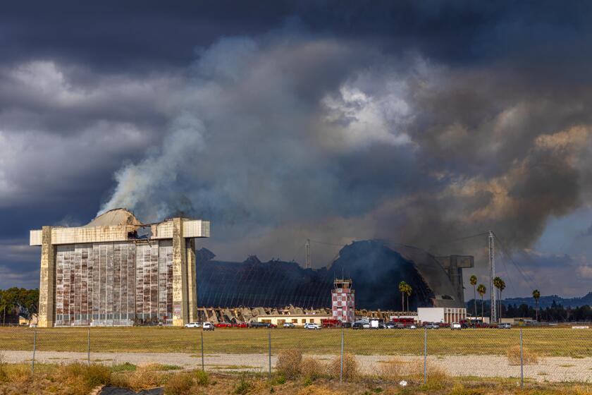 TUSTIN, CA - NOVEMBER 07: A stubborn fire burns a hangar at the former Tustin Air Base on Tuesday, Nov. 7, 2023 in Tustin, CA. (Irfan Khan / Los Angeles Times)