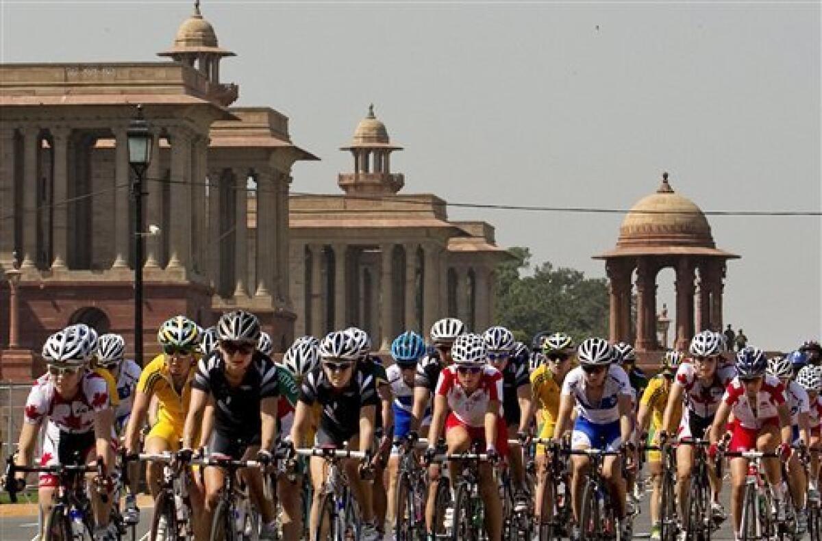 Participants ride past the Indian government's south block building housing some of the important ministries during the women's 112km cycling road race in the Commonwealth Games in New Delhi, India, Sunday, Oct. 10, 2010. (AP Photo/Kevin Frayer)