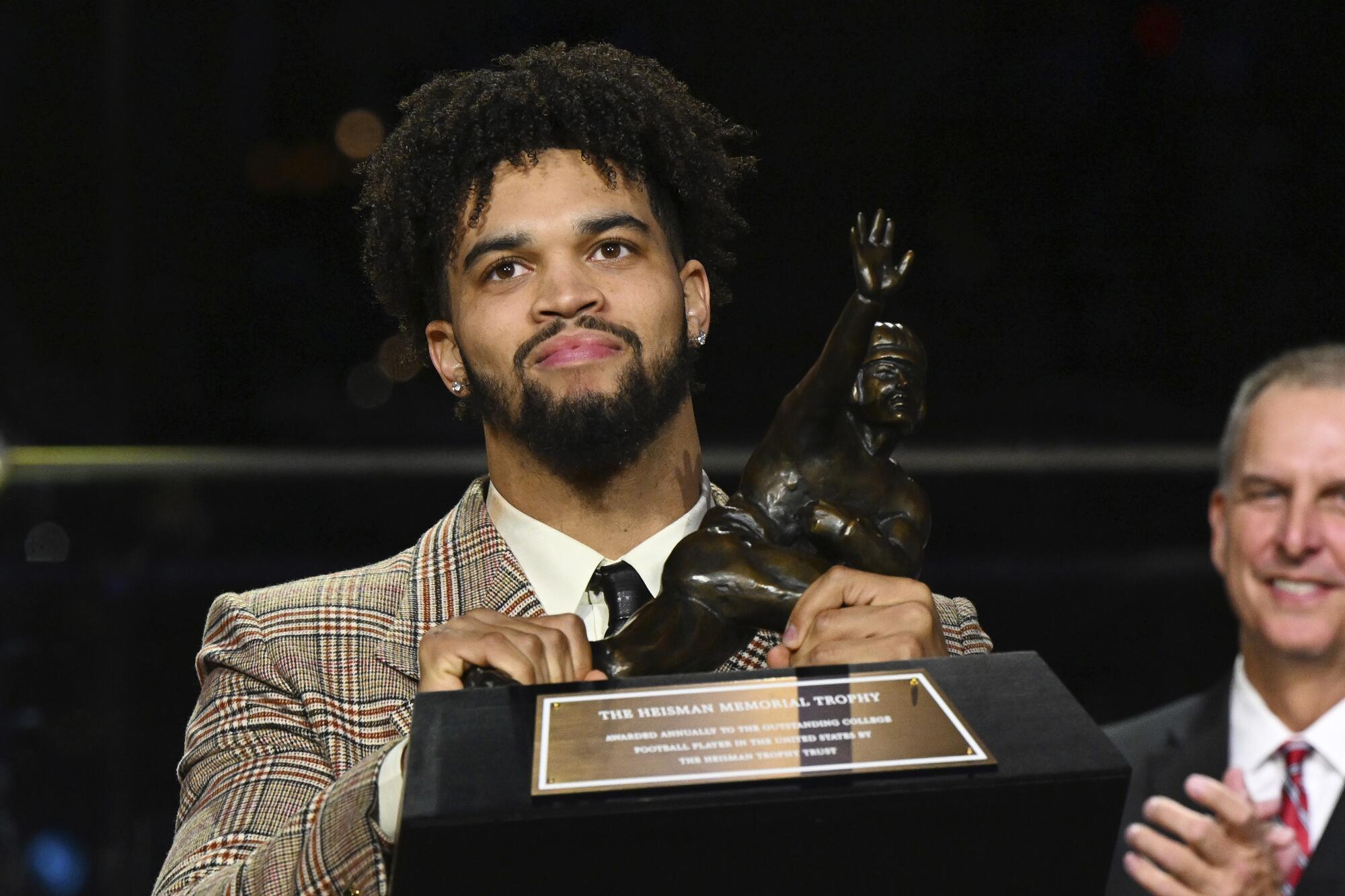 USC quarterback Caleb Williams holds the Heisman Trophy after winning the award.
