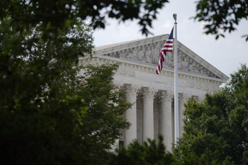 FILE - An American flag waves in front of the U.S. Supreme Court building, Monday, June 27, 2022, in Washington. (AP Photo/Patrick Semansky, File)